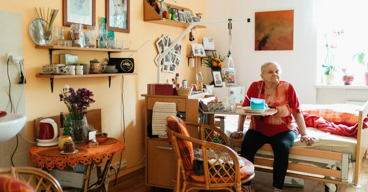 Femme âgée profitant d'une chambre confortable et bien décorée dans une maison de retraite.