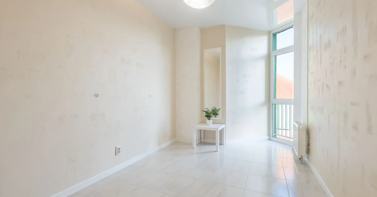 Grande pièce vide et aérée avec une grande fenêtre et une décoration minimale, parfaite pour l'inspiration intérieure.