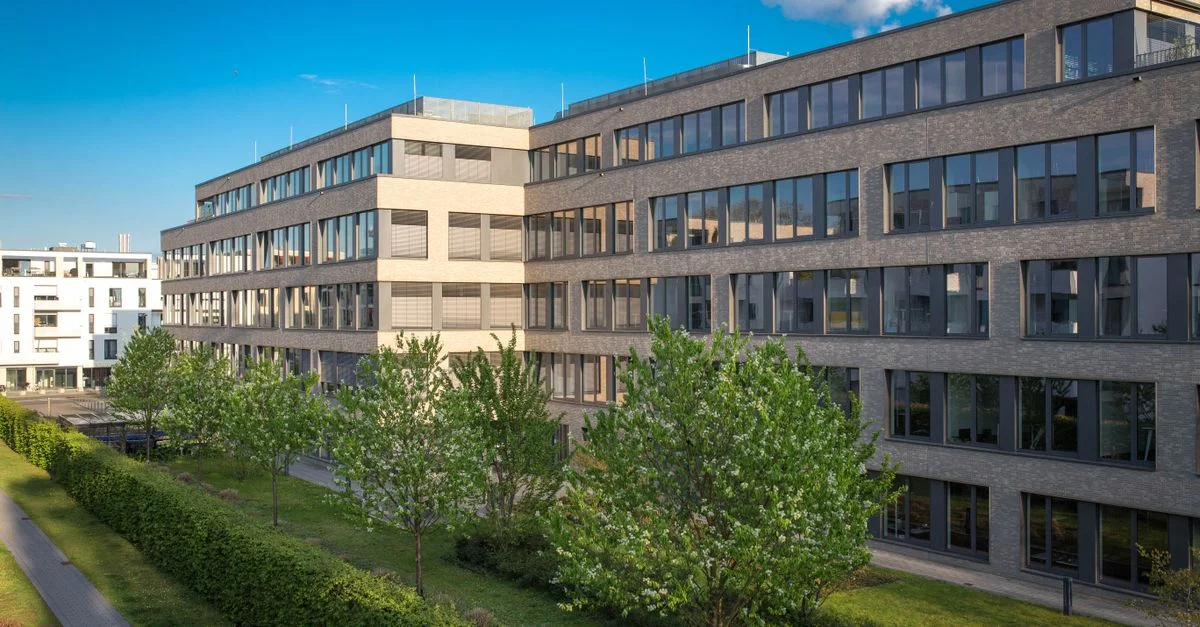 Vue extérieure de bâtiments de bureaux contemporains à Cologne, Allemagne, sous un ciel bleu clair.